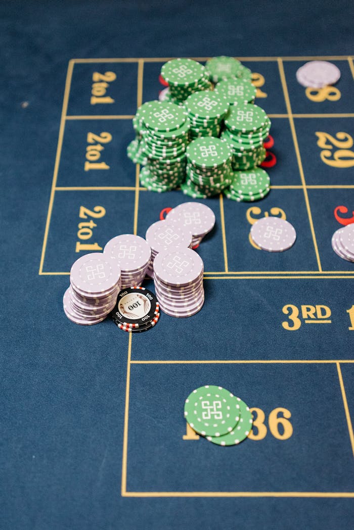 A close-up view of stacked casino chips on a roulette table during a game.